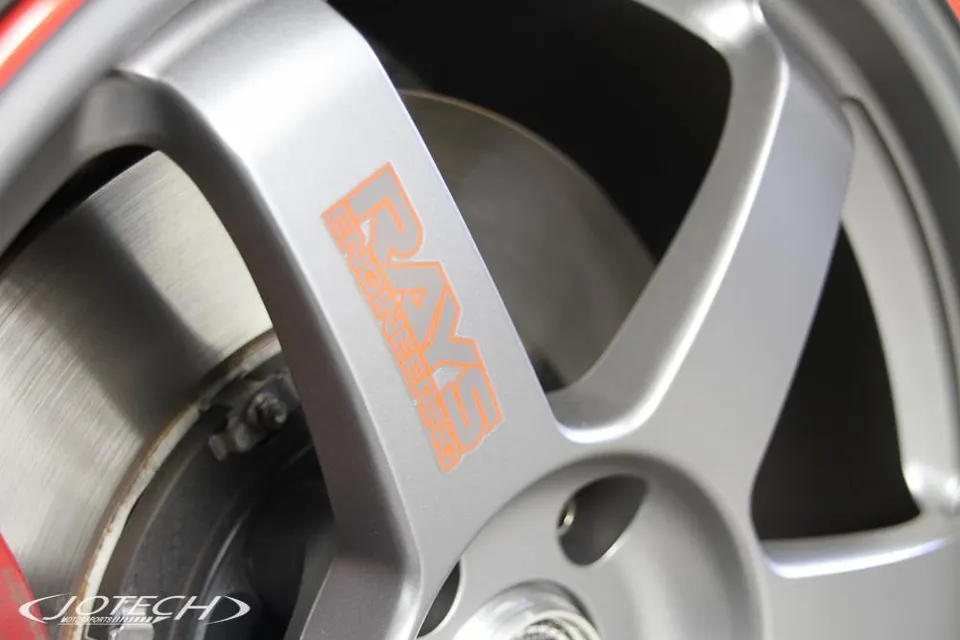 A close-up of a silver Rays Engineering wheel with a brake rotor visible, showcasing the detail of the automotive component.