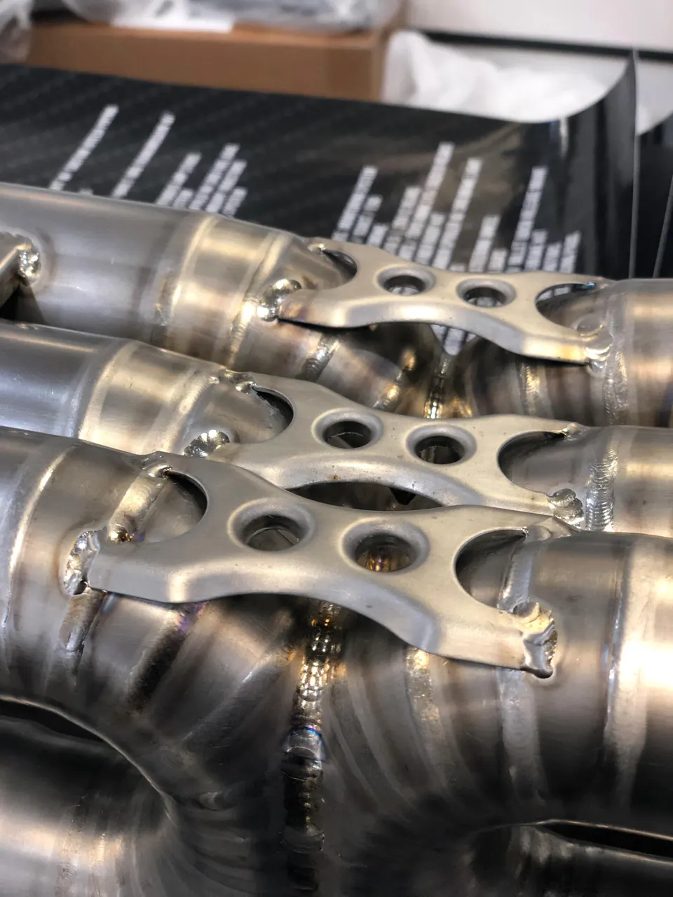 Close-up of custom fabricated exhaust pipes with visible welds, showcasing automotive craftsmanship and detail.