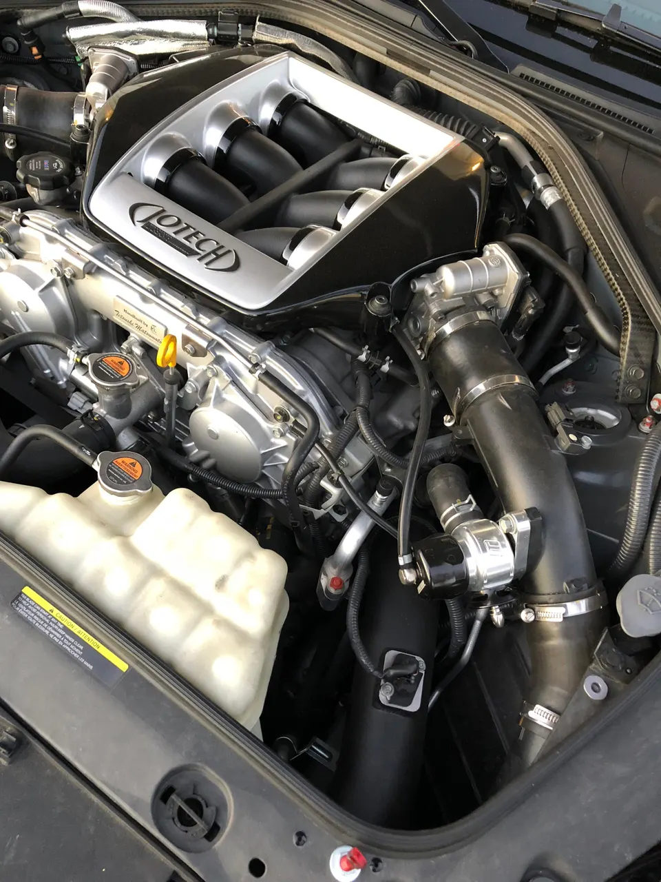 Close-up of a Jotech custom intake manifold and blow-off valve in a high-performance GT-R engine bay.