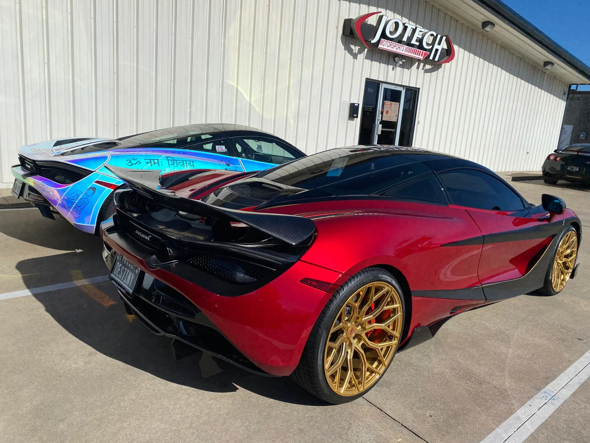 Two custom McLarens, a red 720S with gold wheels and a carbon fiber wing, and an iridescent wrapped McLaren, parked outside Jotech Motorsports.