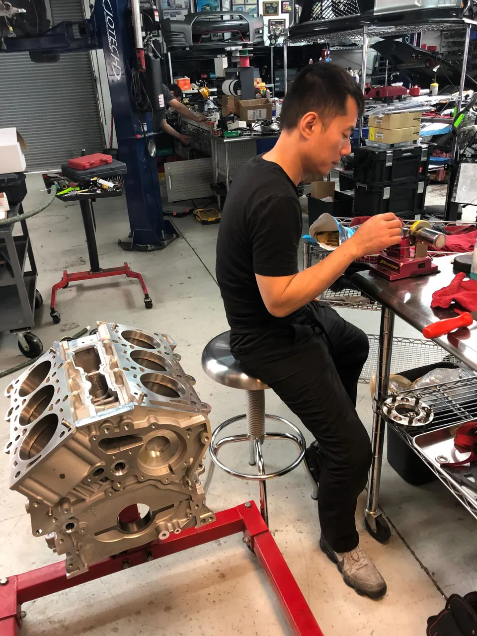 A mechanic assembling an engine block in a performance tuning shop.