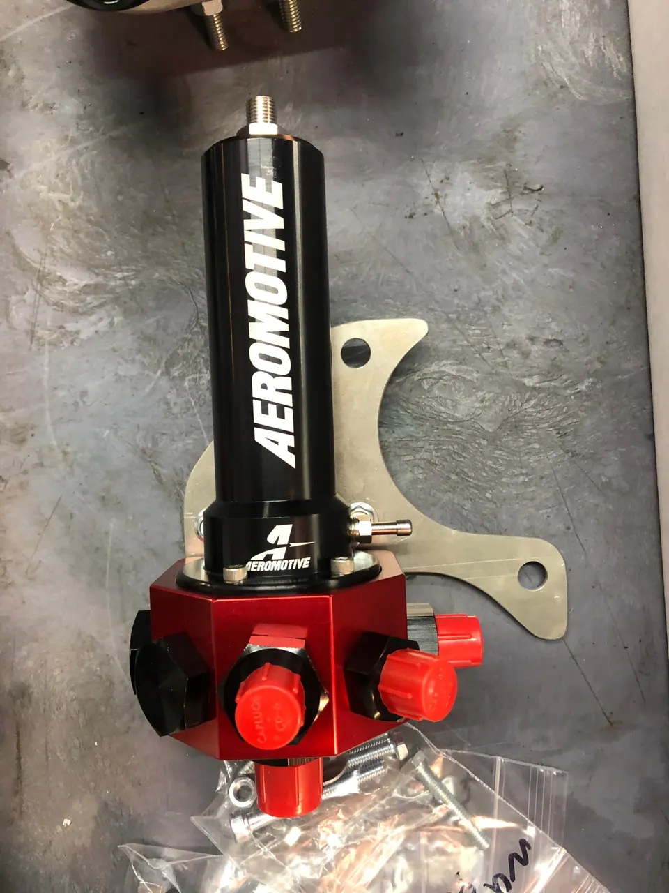 Aeromotive fuel pressure regulator and fuel filter assembly on a workbench, ready for installation.