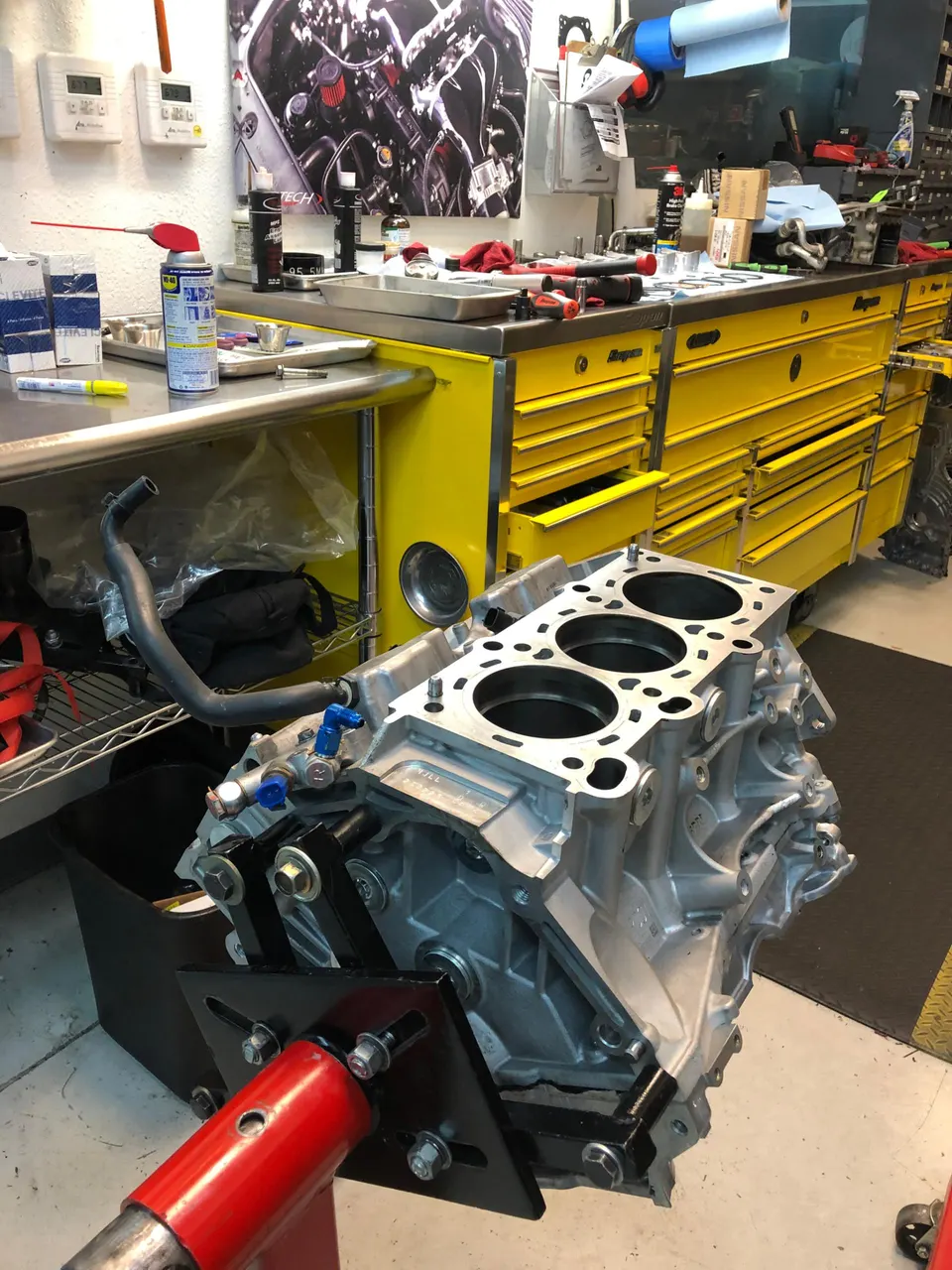 Engine block mounted on an engine stand in a Jotech Motorsports workshop, ready for assembly.