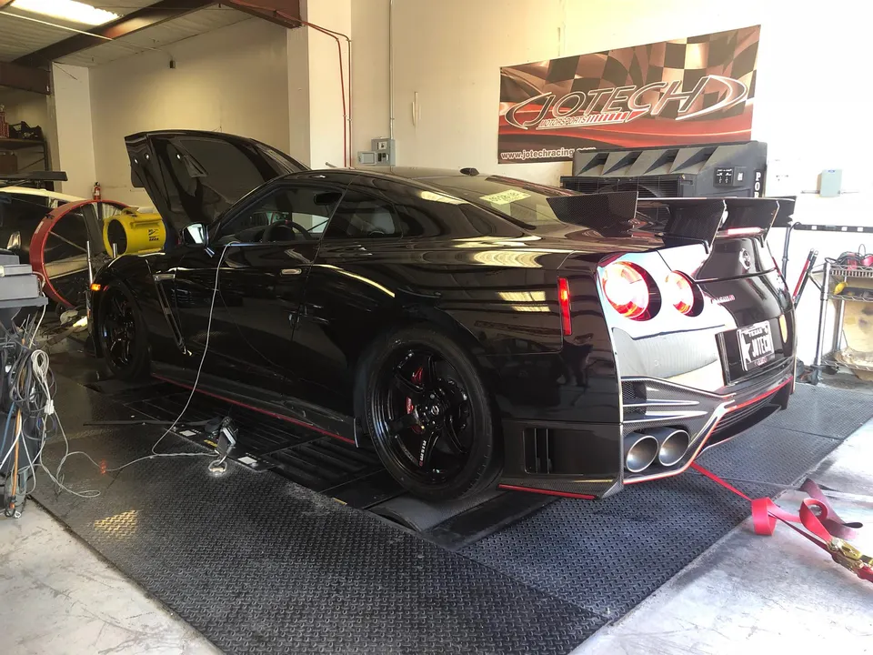 Black Nissan GT-R strapped to a dyno at Jotech Motorsports, ready for performance tuning and power measurement.
