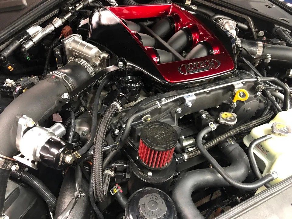 Close-up of a Jotech-tuned Nissan GT-R engine bay featuring a custom red intake manifold, blow-off valve, and performance air filter.