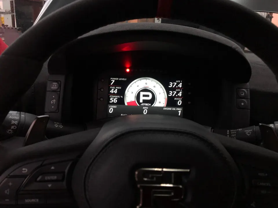 Nissan GT-R interior showing a Jotech digital dashboard displaying fuel pressure, ethanol, AFR, and boost.