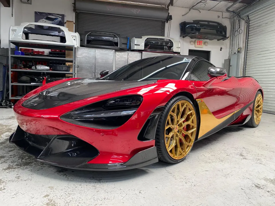 Red and gold McLaren 720S with custom gold wheels and carbon fiber aero parked in a performance tuning shop