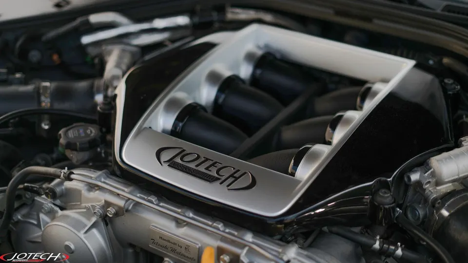 Close-up of a Jotech custom intake manifold in a high-performance engine bay, showcasing the detailed engineering.
