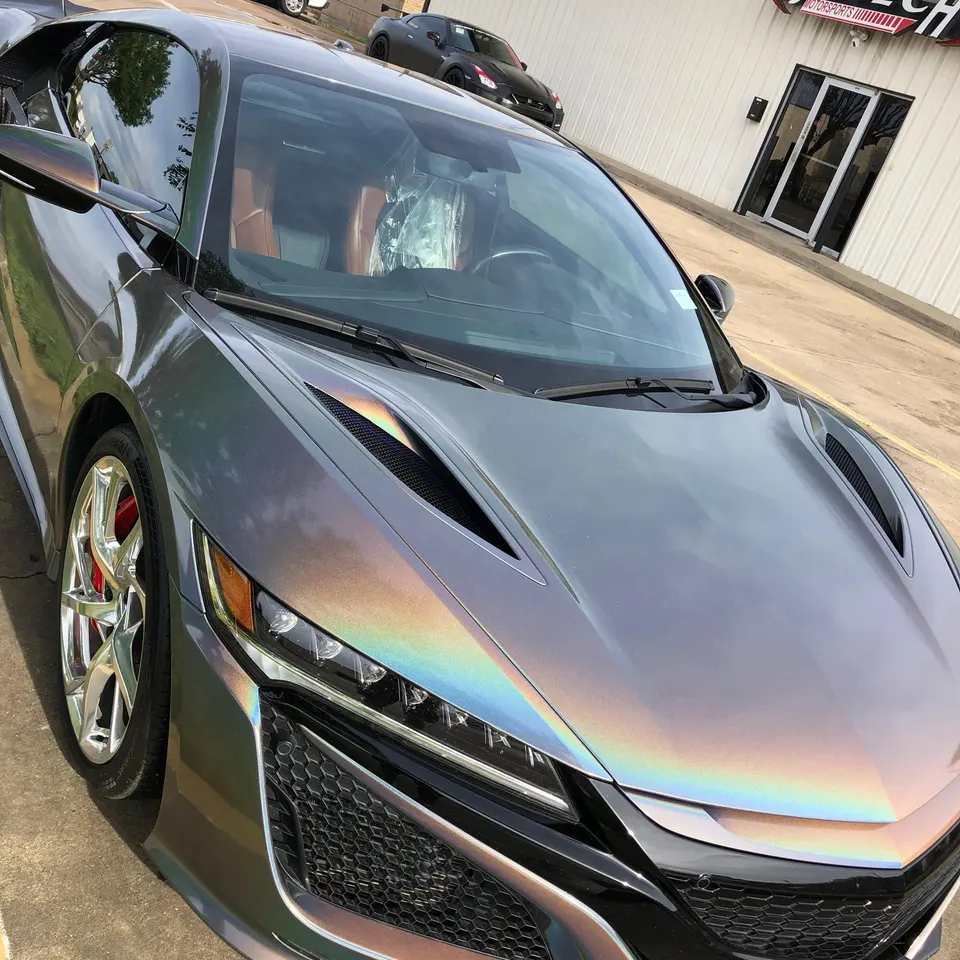 Acura NSX with an iridescent wrap parked outside Jotech Motorsports, showcasing its unique color-shifting finish.