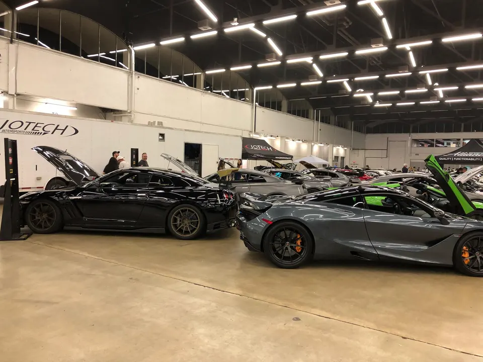High-performance Nissan GT-R and McLaren supercars on display at a car show event, with Jotech Motorsports branding visible.