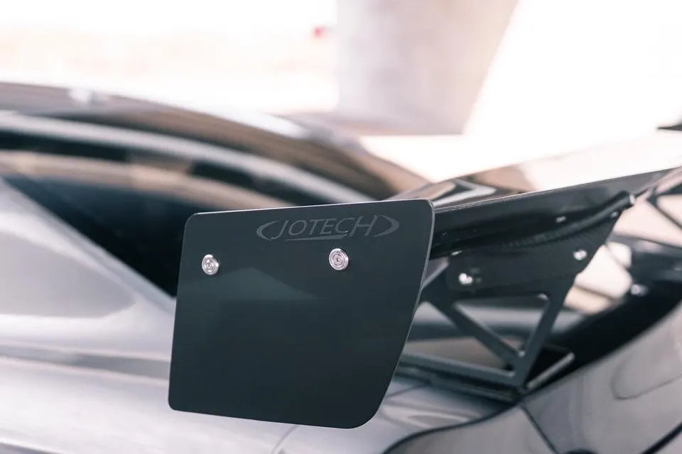 Close-up of a Jotech carbon fiber rear wing on a performance car, showcasing the aerodynamic detail.