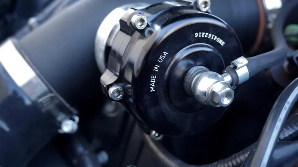 A close-up of a black aftermarket blow-off valve in an engine bay, with 'MADE IN USA' visible on its side.