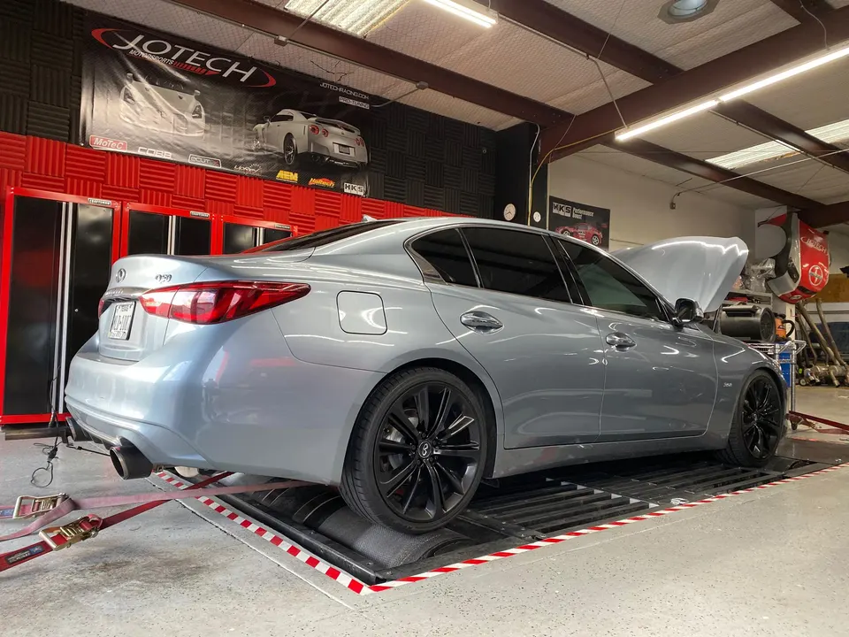 Grey Infiniti Q50 sedan on a Jotech Motorsports dyno for performance tuning and testing.