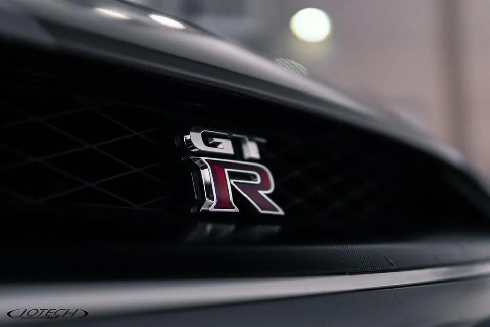 Close-up of the Nissan GT-R badge on the front grille of a performance car.