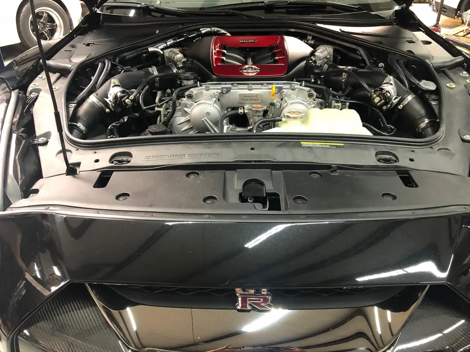Nissan GT-R R35 engine bay showcasing the Nismo intake system and red engine cover.