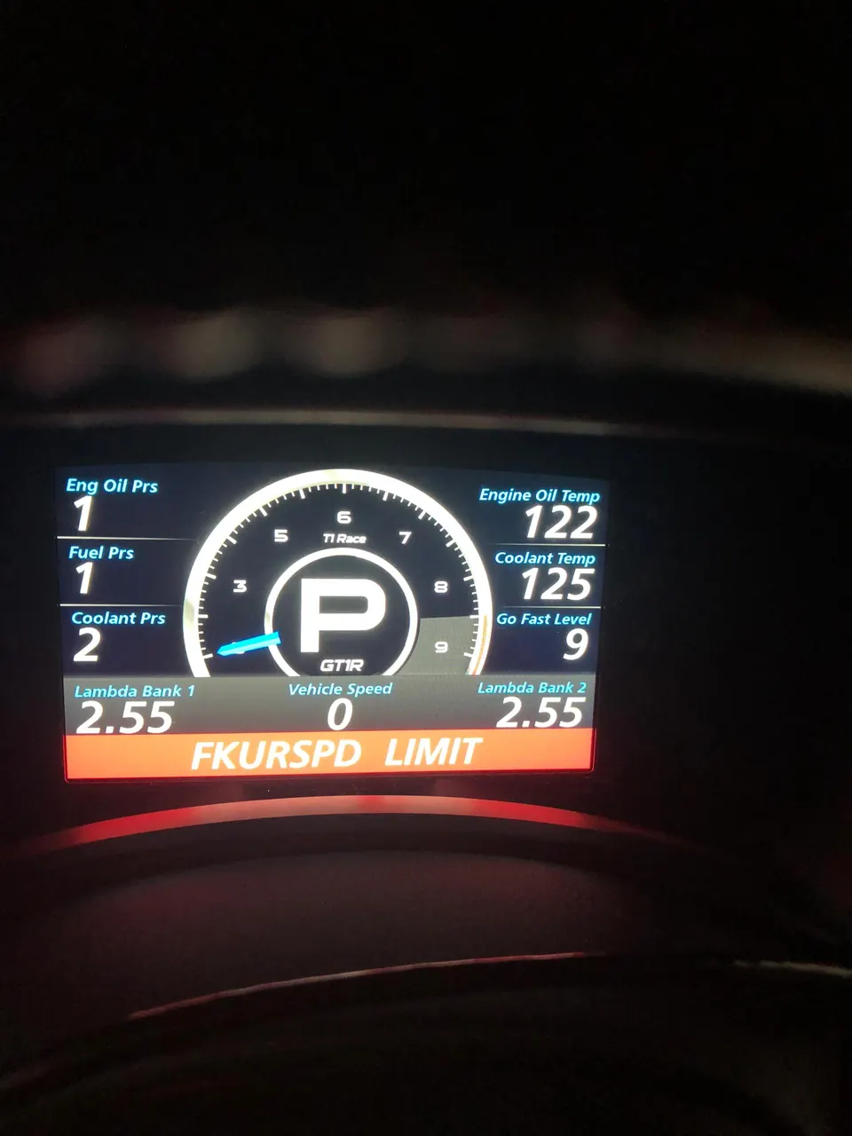 Digital dashboard displaying engine parameters like oil pressure, fuel pressure, coolant temperature, and lambda readings.