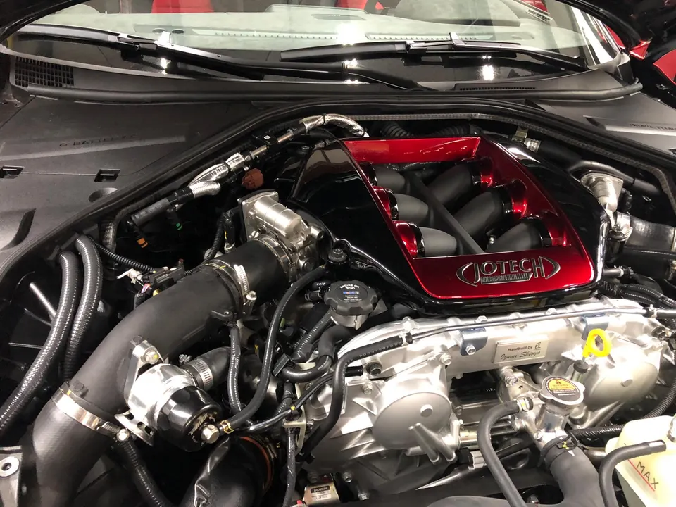 Close-up of a Jotech-tuned Nissan GT-R VR38DETT engine bay featuring a custom red intake manifold and boost piping.
