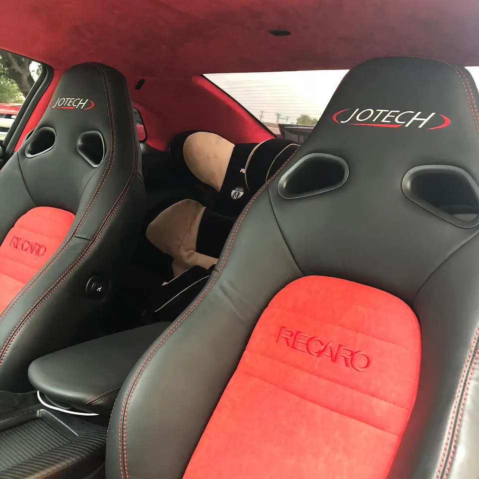 Custom red and black Recaro Jotech sports seats with a matching red headliner in a performance car interior.