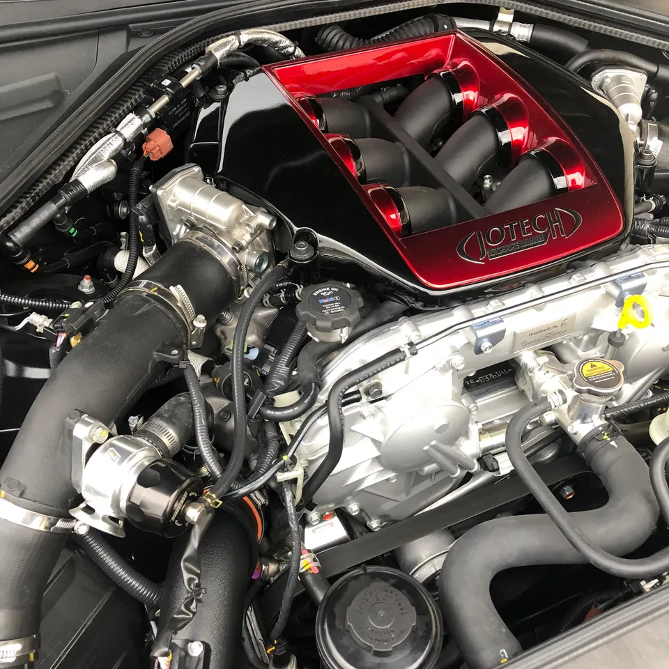 Close-up of a Jotech tuned Nissan GT-R engine bay featuring a custom red and black intake manifold and performance parts.