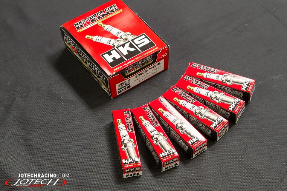 HKS Super Fire Racing Iridium spark plugs in their individual red boxes, ready for installation.