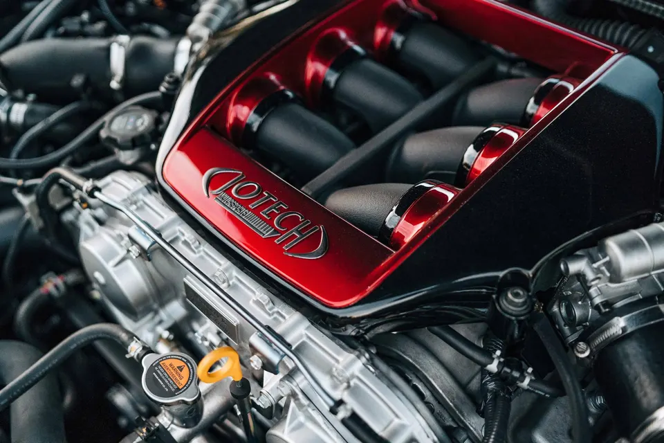 Close-up of a Jotech custom red intake manifold in a high-performance engine bay.