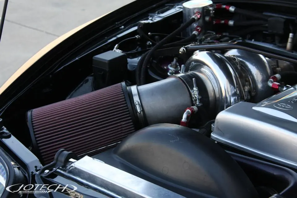 Close-up of a high-performance engine bay featuring a large turbocharger and aftermarket air intake system.