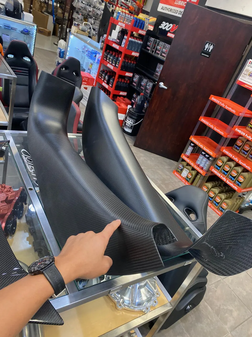 Carbon fiber intake ducts on display in a performance tuning shop.