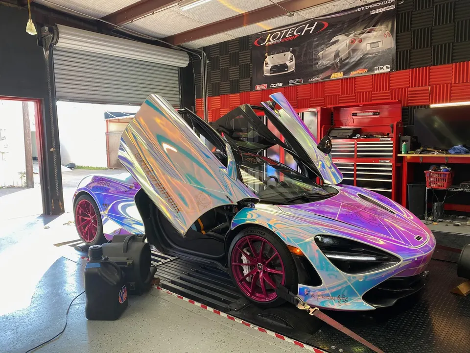 Holographic wrapped McLaren 720S with pink wheels strapped to a dyno at Jotech Motorsports.