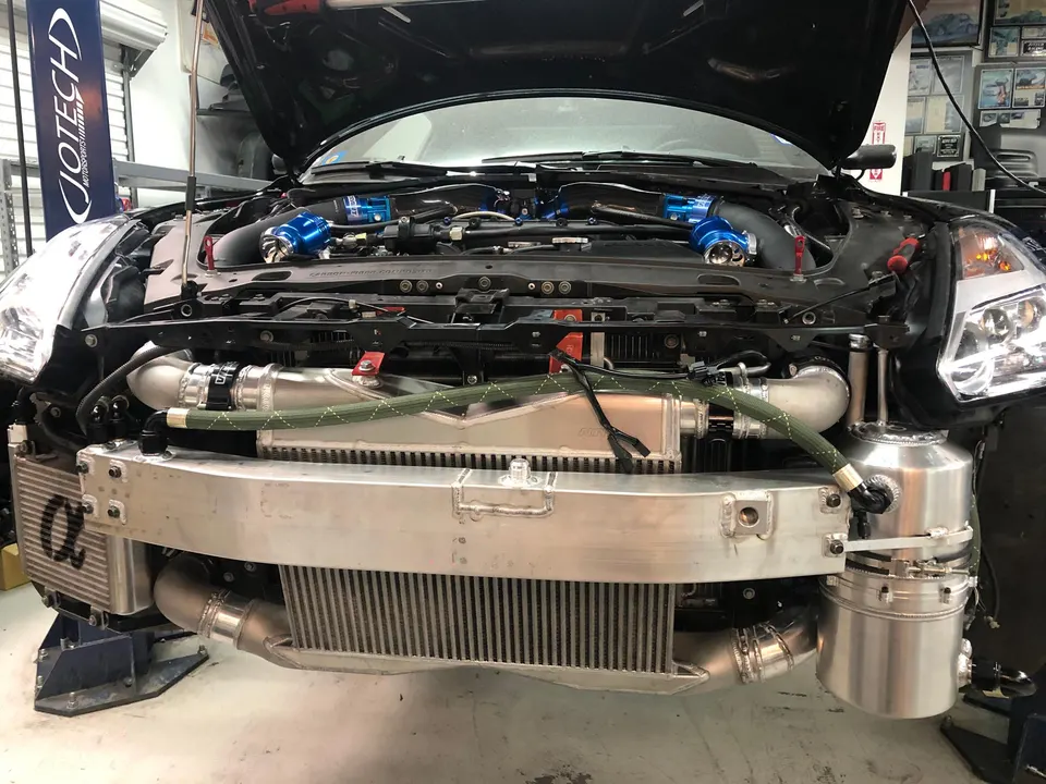 Nissan 350Z with front bumper removed, showcasing a large intercooler, boost piping, and engine bay modifications at Jotech Motorsports.