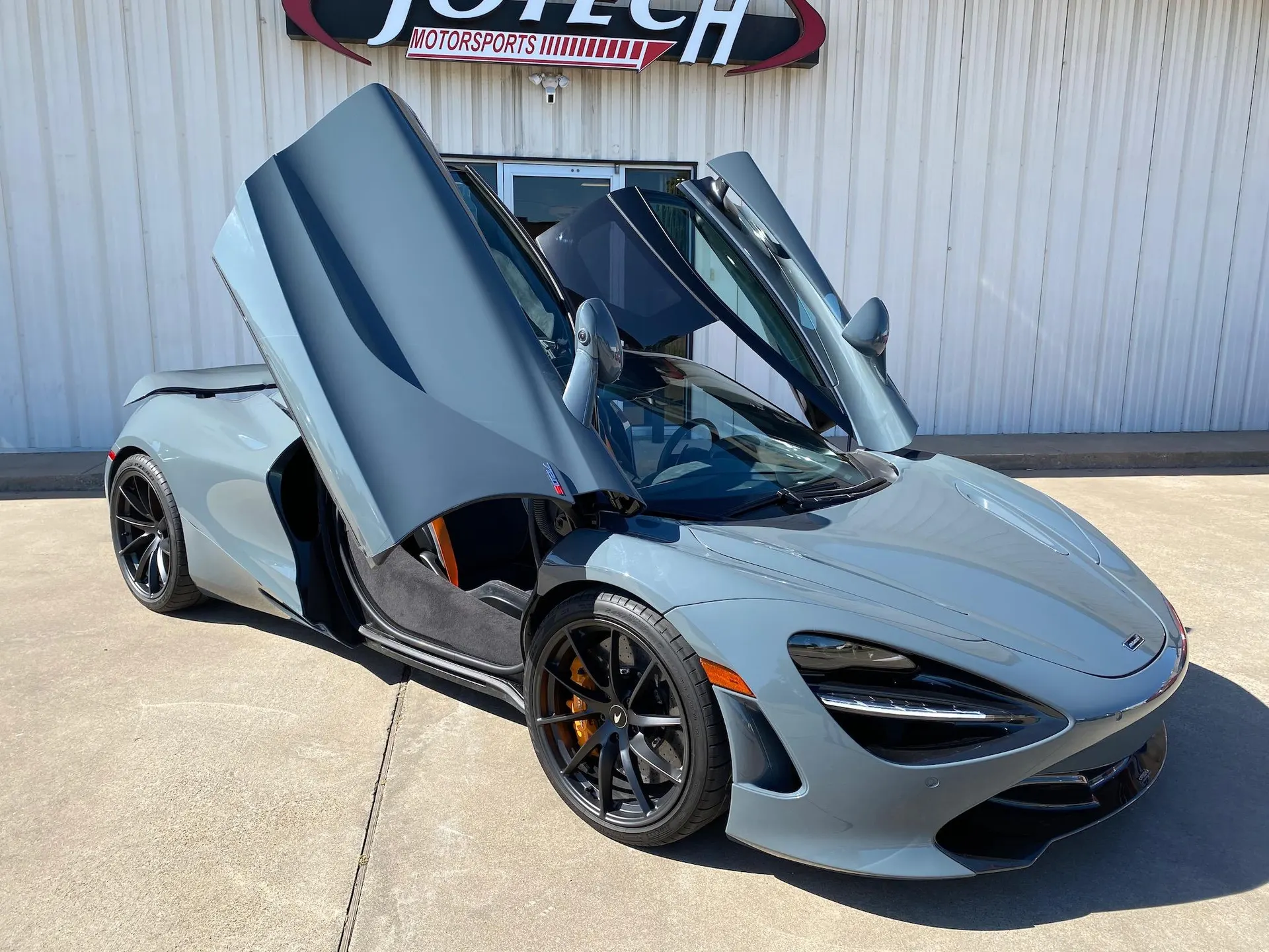 Grey McLaren 720S with butterfly doors open, parked outside Jotech Motorsports.