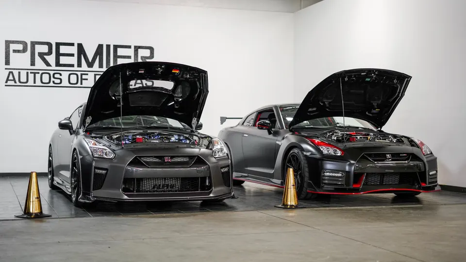 Two modified Nissan GT-Rs with open hoods displaying their high-performance engines in a clean showroom setting.