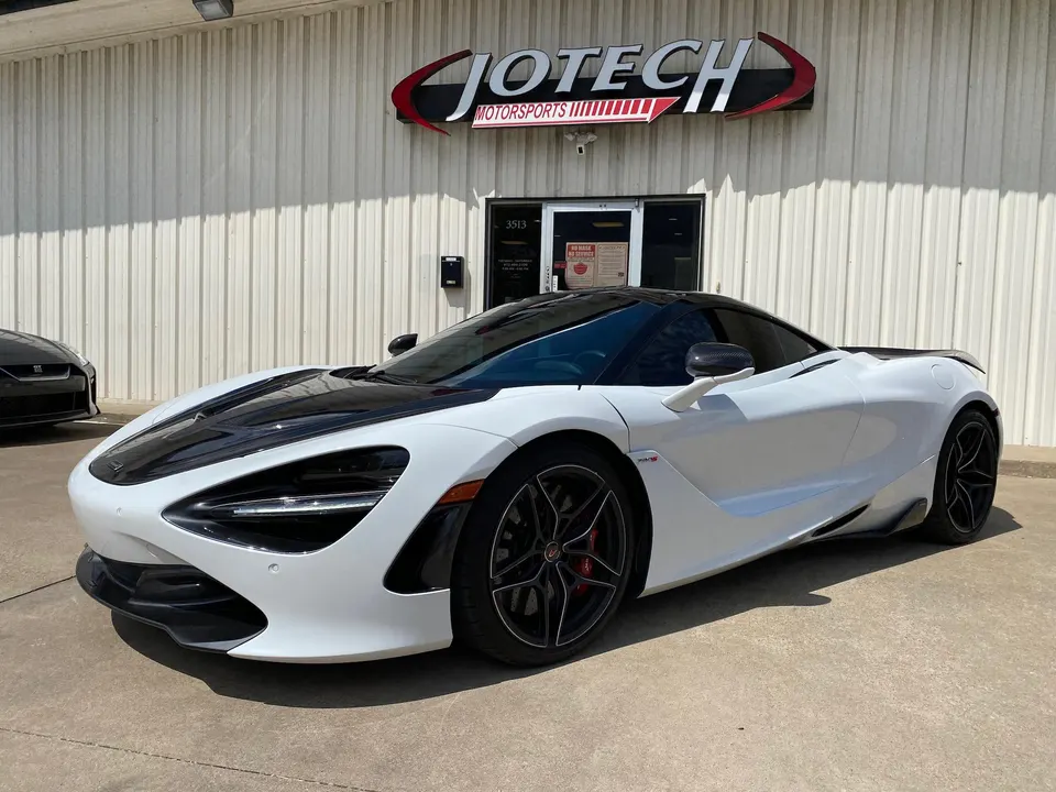 White McLaren 720S with black carbon fiber accents parked outside Jotech Motorsports performance tuning shop.