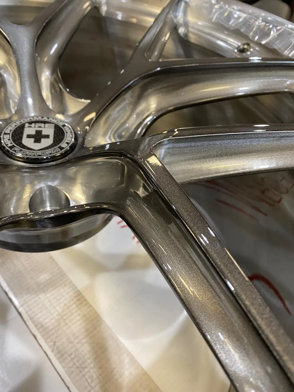 Close-up detail of a silver HRE FlowForm performance wheel, showcasing the spokes and center cap.