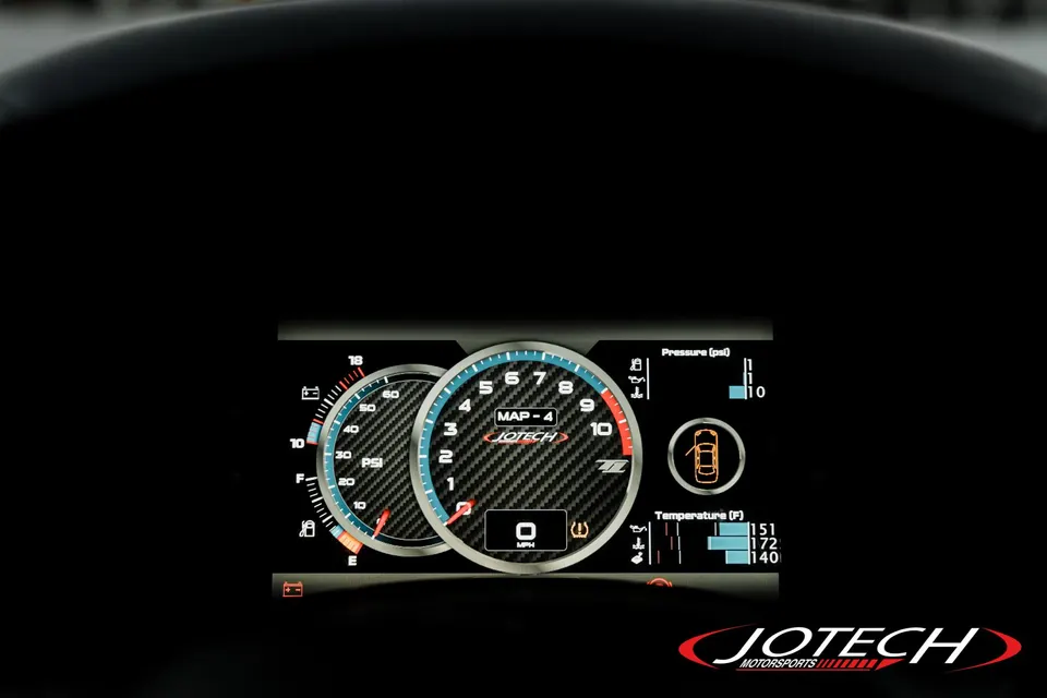 Jotech Motorsports custom digital dashboard display with carbon fiber texture showing gauges and vehicle data.