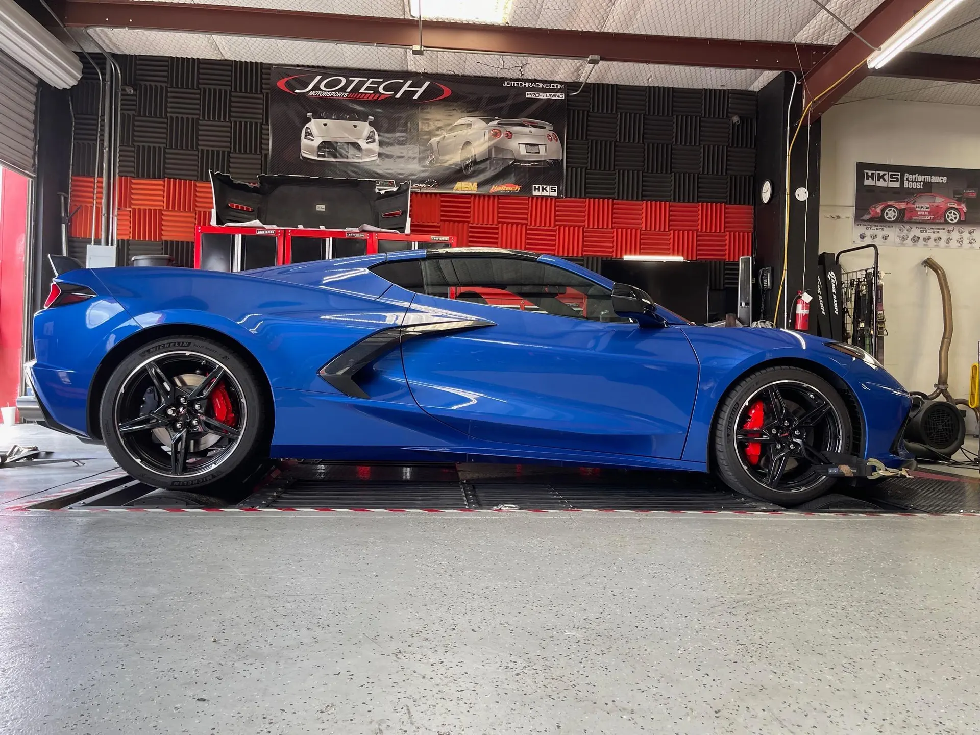 Blue Chevrolet Corvette C8 strapped to a dynamometer at Jotech Motorsports for performance tuning.