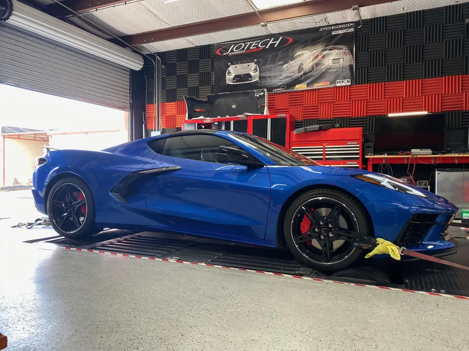 Blue C8 Corvette strapped to a dynamometer at Jotech Motorsports for performance tuning.