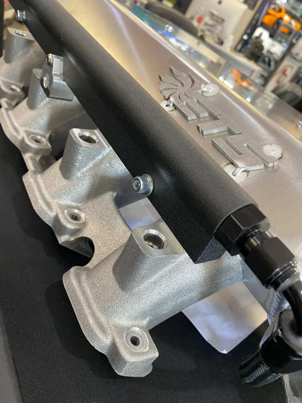 Close-up of a performance intake manifold and fuel rail with AN fittings, likely for a high-horsepower build.