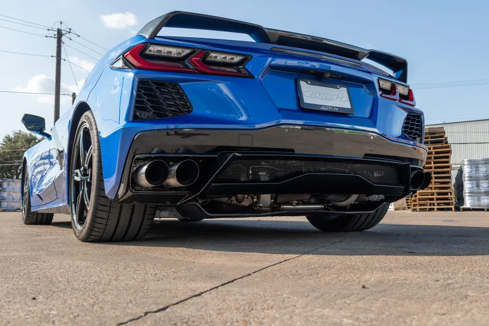 Rear view of a blue C8 Corvette showcasing its aftermarket exhaust system and aggressive rear diffuser.