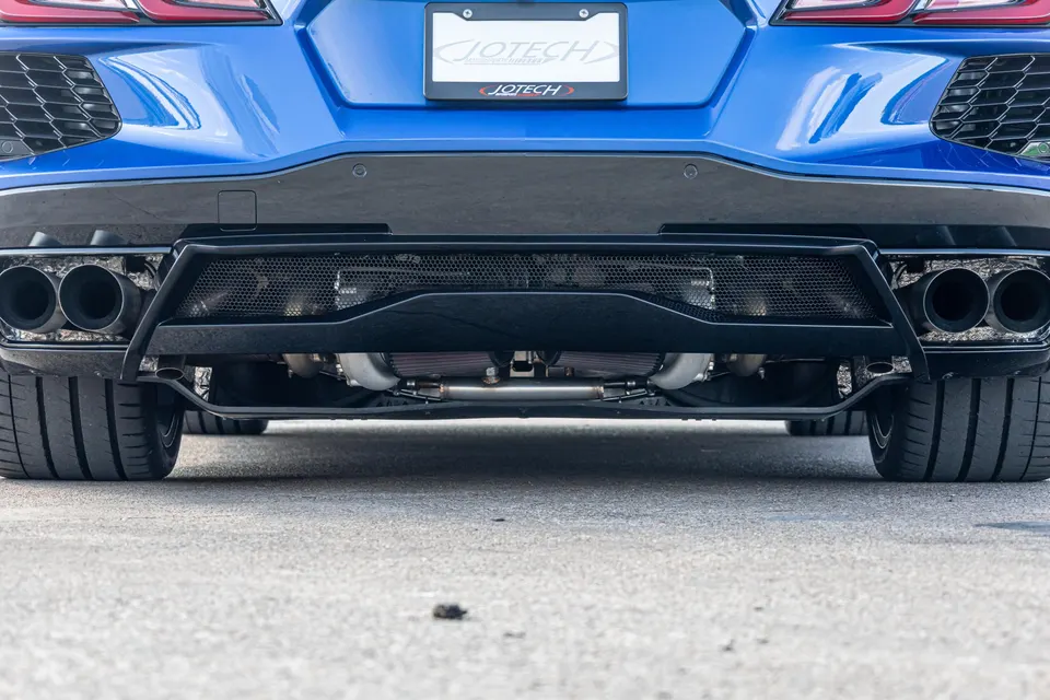 Rear view of a blue Corvette C8 with a custom Jotech rear diffuser and quad exhaust tips, showcasing performance tires.