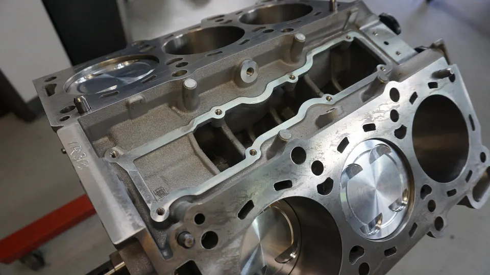 Close-up of a VR38 engine block with pistons during assembly, showcasing the internal components of a high-performance engine.