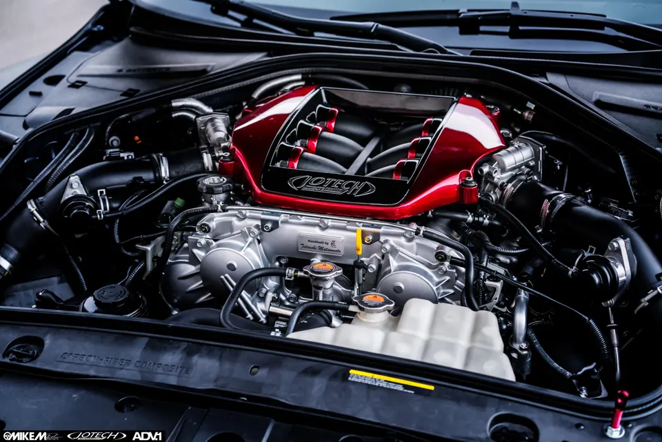 Close-up view of a Jotech-tuned Nissan GT-R R35 VR38DETT engine bay with a custom red intake manifold.