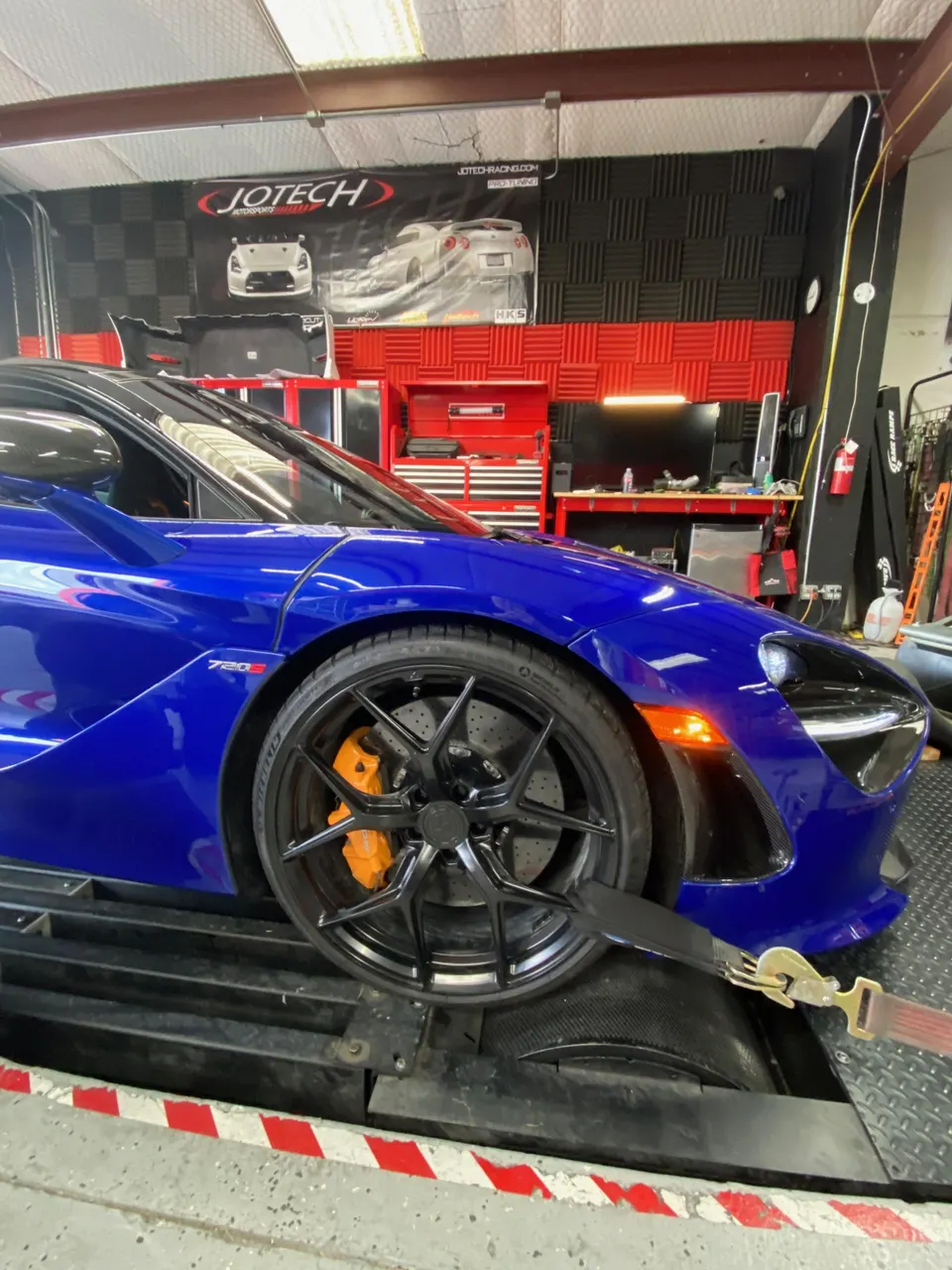 Blue McLaren 720S strapped to a dynamometer at Jotech Motorsports for performance tuning.