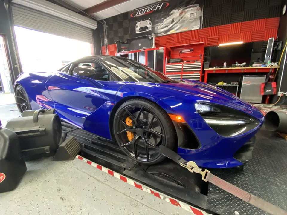 Blue McLaren 720S strapped to a dynamometer at Jotech Motorsports for performance tuning.
