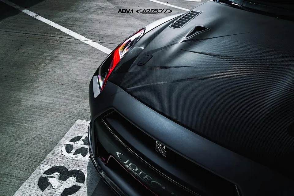 Close-up of a Jotech Nissan GT-R's carbon fiber hood and front bumper, featuring ADV.1 branding.
