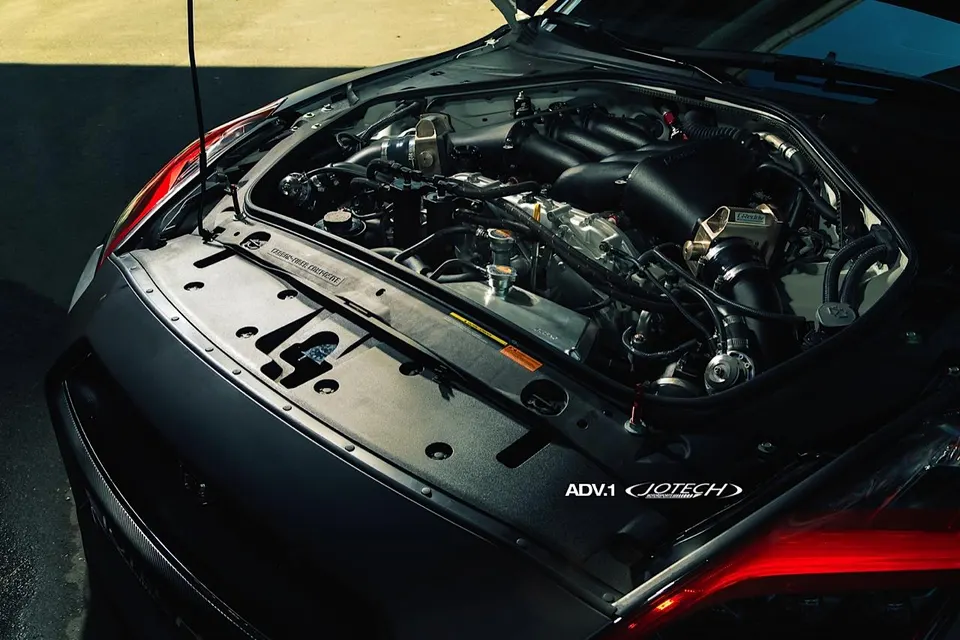 Close-up of a Nissan GT-R engine bay featuring Jotech Motorsports and ADV.1 aftermarket induction system.