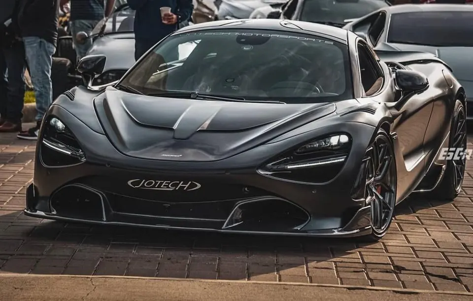 A dark grey McLaren 720S with Jotech Motorsports branding parked outdoors at a car event.