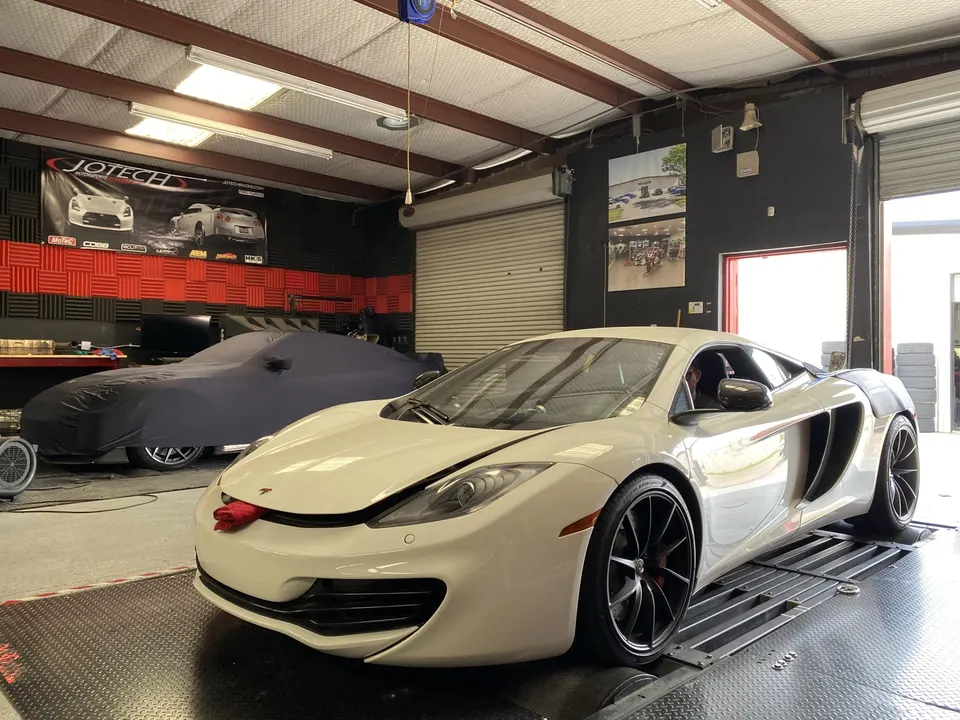 White McLaren supercar on a dyno at Jotech Motorsports performance tuning shop