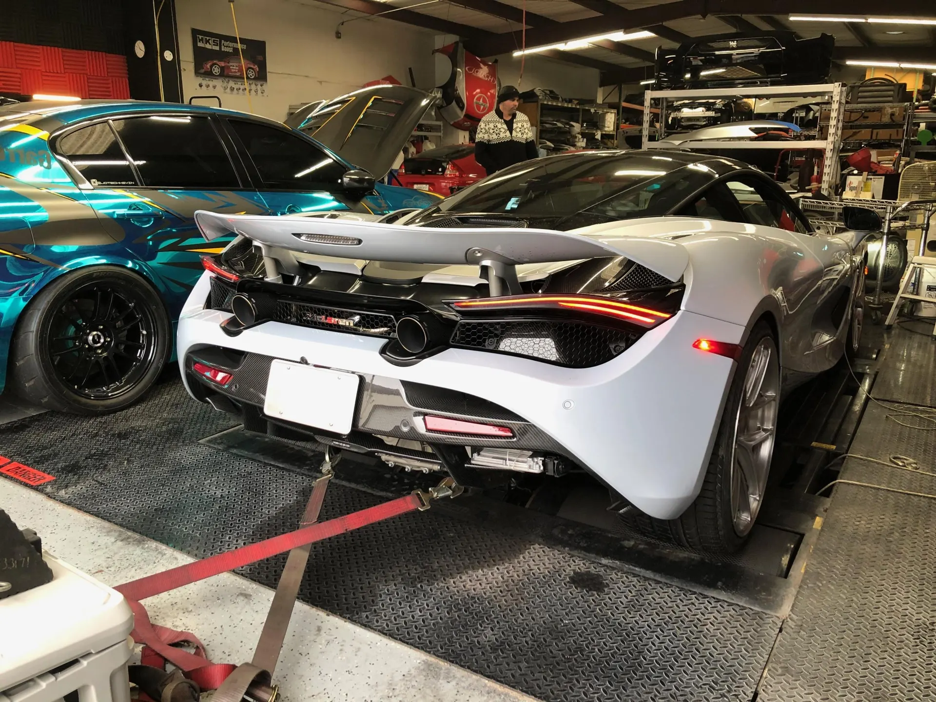 McLaren 720S strapped to a dyno for performance tuning at Jotech Motorsports, with another car in the background.