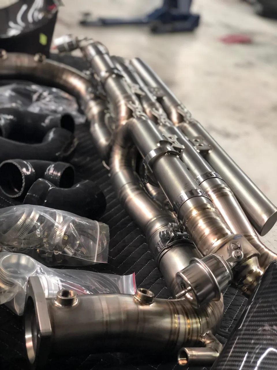 High-performance exhaust headers, wastegates, and boost piping laid out in a tuning shop.