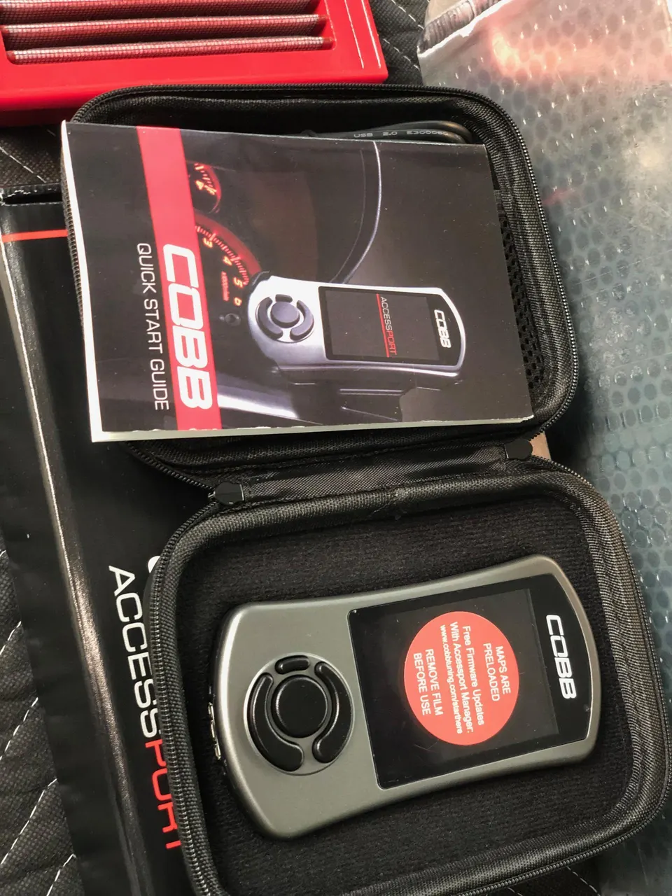 Cobb Accessport V3 tuning device in its case with quick start guide, ready for performance tuning.